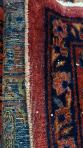 Mittlerer Abschnitt der beschädigten Teppichkante – Fäden lösen sich