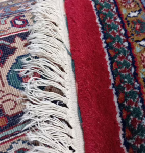 Nahaufnahme der verschlissenen Fransen, die durch Kettelung ersetzt werden sollen